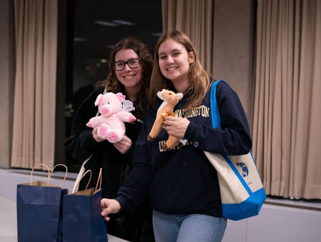 two students hold stuffed animals