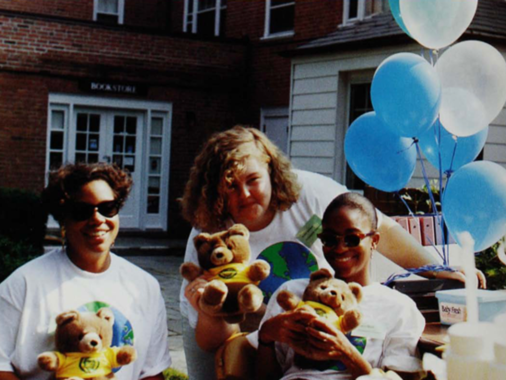 Photo of three former Mount Vernon Campus students holding teddy bears outside at an event