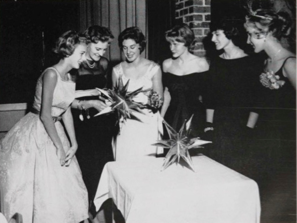 Black and white photo of a group of women dressed in evening gowns