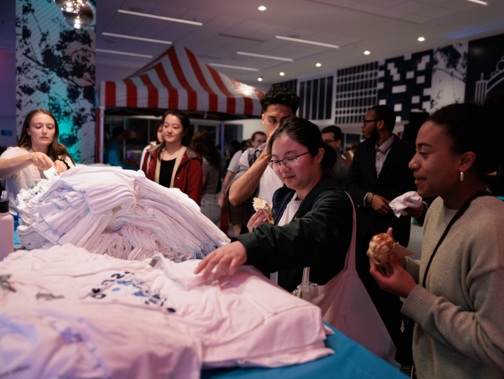A group of students picking up a free "class of" t-shirt at Last Night