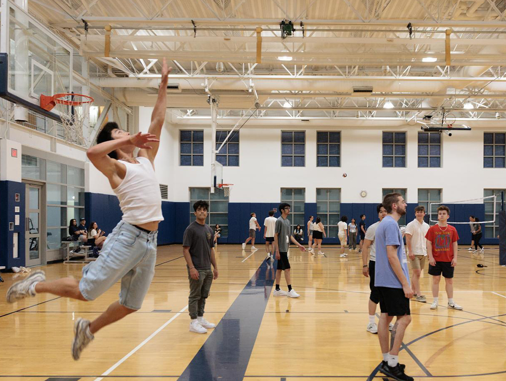 A student goes up for a serve while playing volleyball in Lerner.