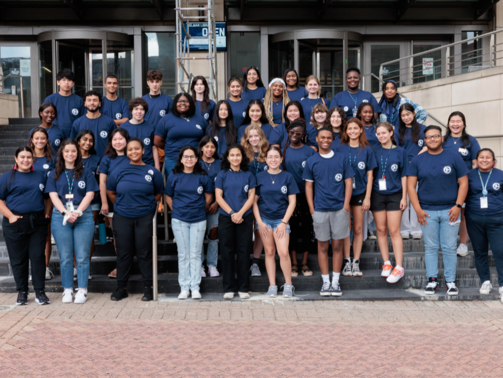 A large group of Peer Guides pose on the steps of Gelman Library