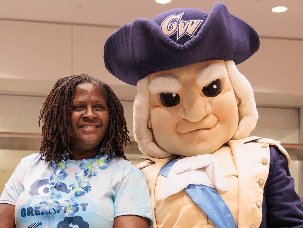 Vice Provost Colette Coleman smiles next to the George Washington mascot