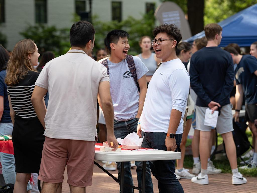 Three students are talking at an MSSC block party table