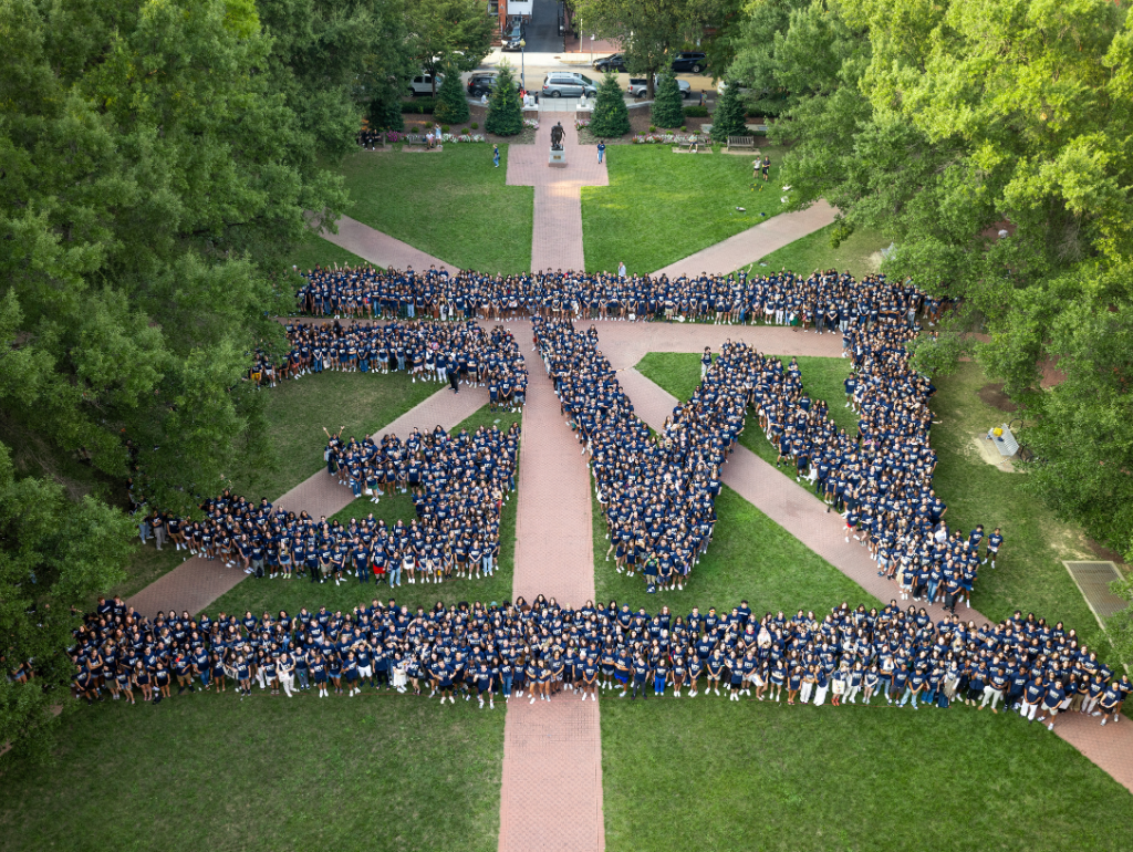Members of the GW class of 2023 arranged in University Yard in the shape of the GW monogram logo