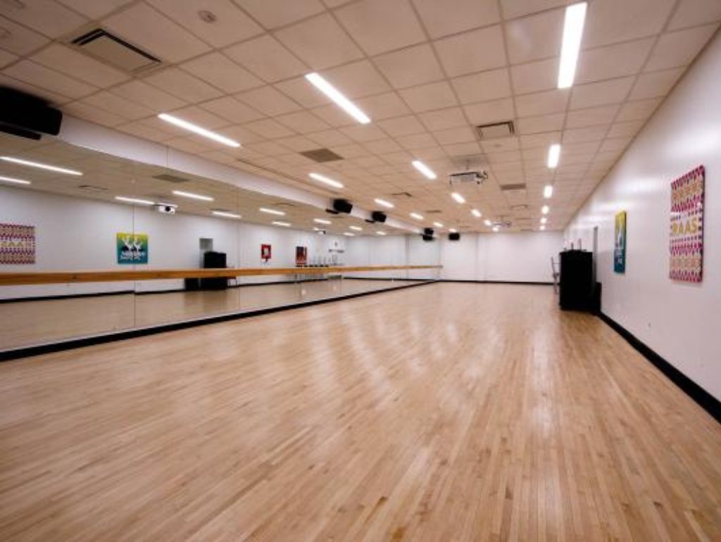 Dance studio in District House with wood floor and mirrored wall