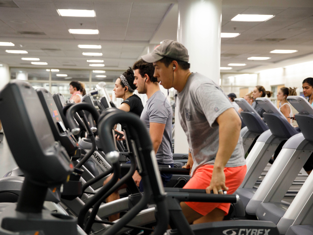 Several students utilizing elliptical machines