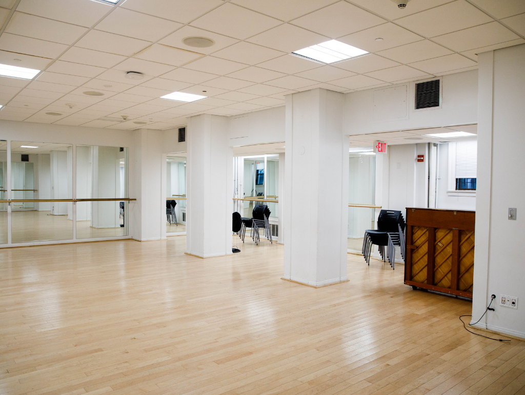 Theater space in Mitchell Hall with wood floors and a mirrored wall