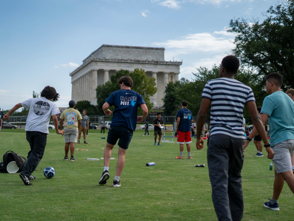 STudents playing a game of pick-up soccer on the National Mall with the Lincoln Memorial in the background