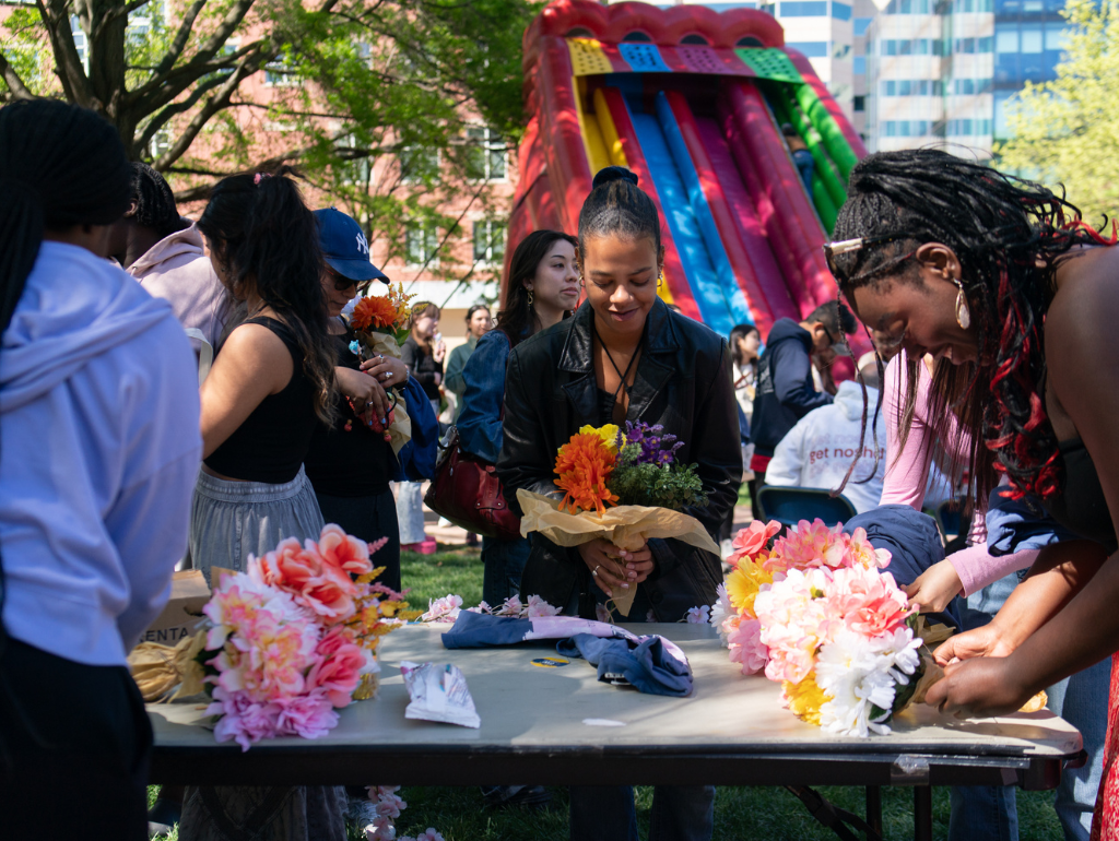 A group of students building bouquets of flowers in UYard at Blossom Bash