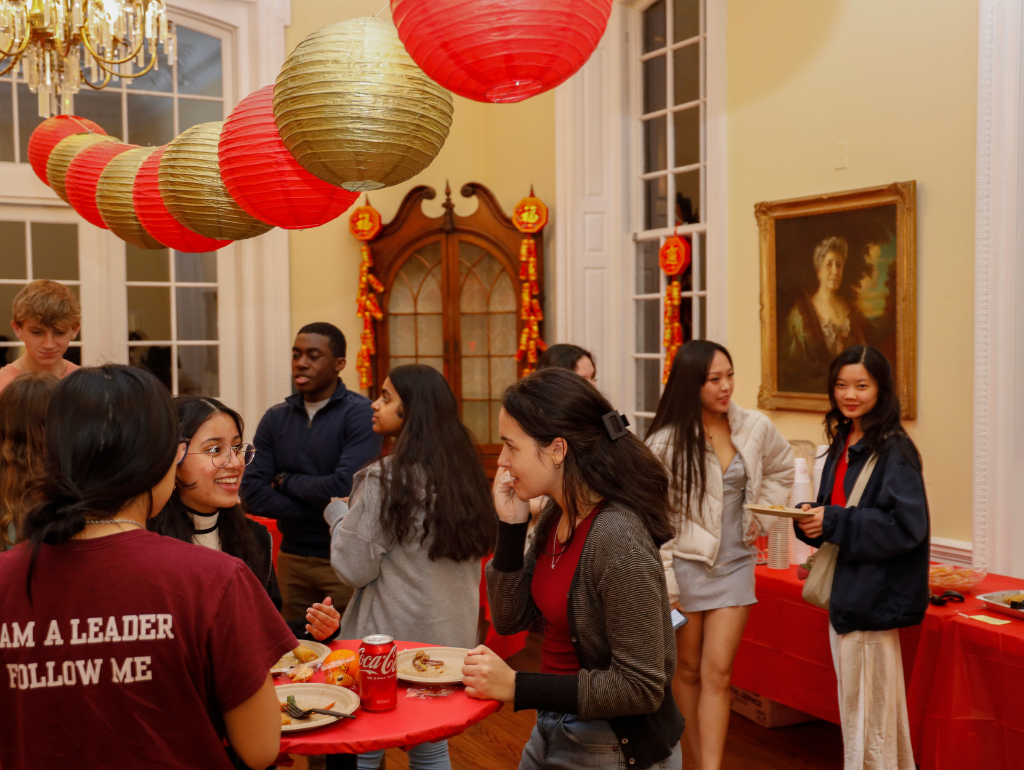 Students mingling in Post Hall for Lunar New Year; red and gold paper lanterns are hung from the ceiling