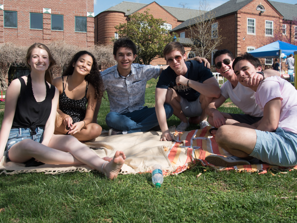 Six students lounging on a picnic blanket on the Vern Quad